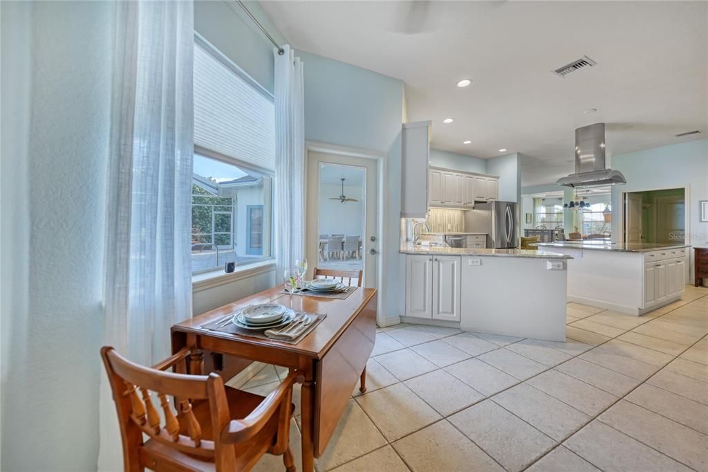 kitchenette area looking back at kitchen with views to pool and canal out the window. Door pictured is to pool and lanai