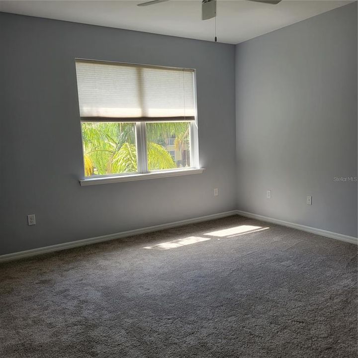 Primary bedroom with two windows and water view