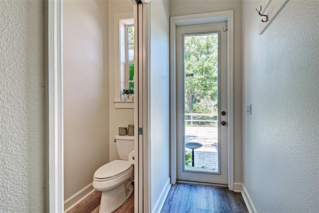 POWDER ROOM WITH REAR ENTRANCE TO POOL AREA AND YARD.