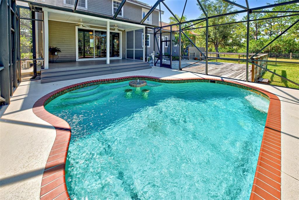 FREE FORM SALTWATER POOL WITH BEVERAGE TABLE & SEATING.