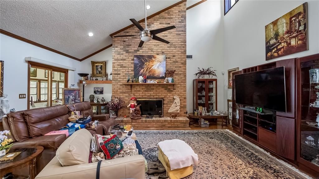 Great Room with brick fireplace vaulted ceiling door to florida room