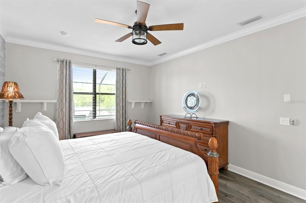 The master suite includes LVT flooring, a ceiling fan and crown molding