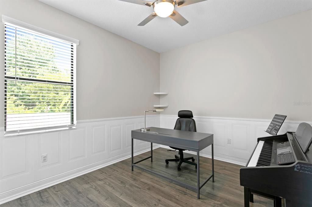 The 4th bedroom is being used as a home office and has decorative wainscoting