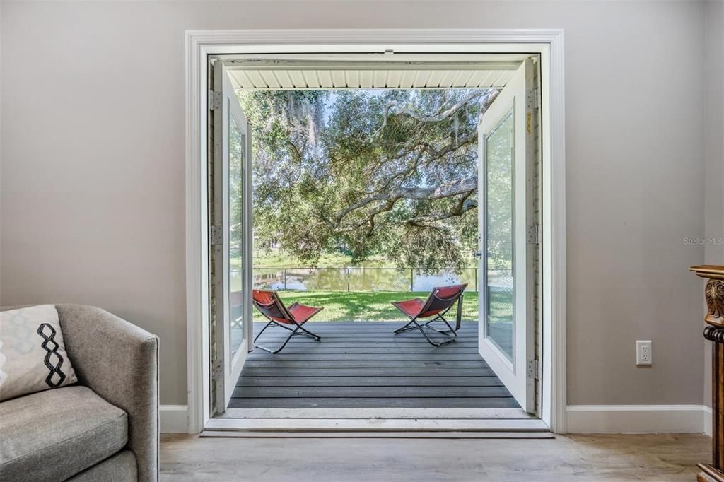 French Doors with Blinds in the glass open to a TREX deck overlooking the expansive BY and Pond