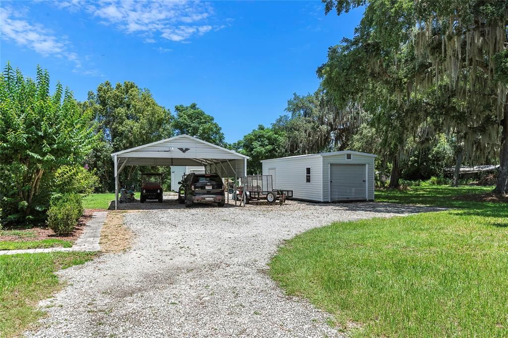 Carport off of 3 car garage and sheds