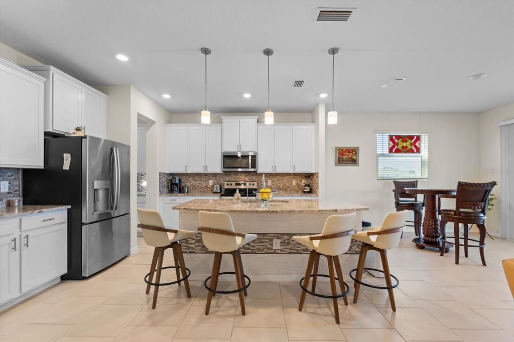 Custom tile featuring copper and silver accents complement the gorgeous granite countertops.