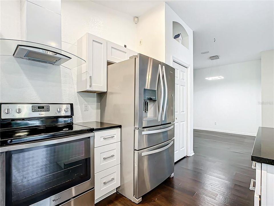 Centralized kitchen; which was recently updated in 2020, features stainless-steel appliances, granite countertops, hardwood cabinets with soft close, a breakfast bar, and a dry bar with additional cabinets for added storage.