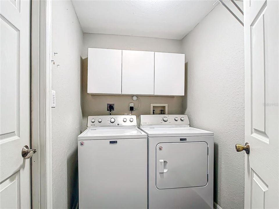 Inside laundry room equipped with a washer & dryer, and a wall safe for long guns.