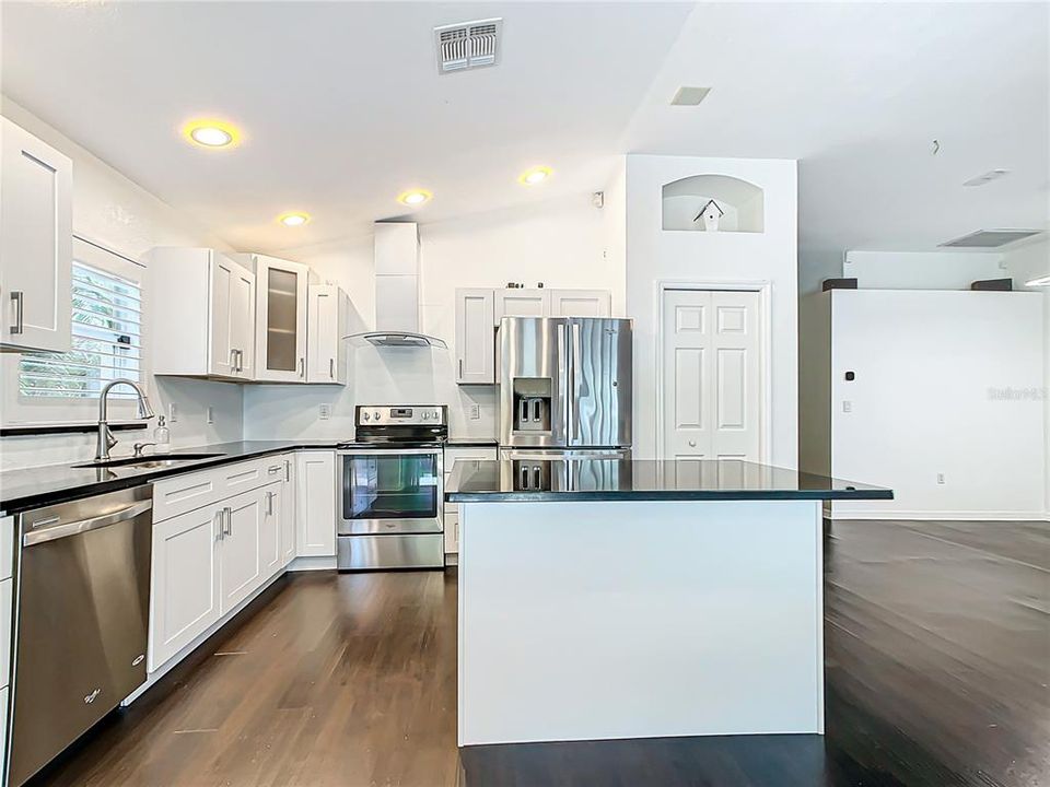 Centralized kitchen; which was recently updated in 2020, features stainless-steel appliances, granite countertops, hardwood cabinets with soft close, a breakfast bar, and a dry bar with additional cabinets for added storage.