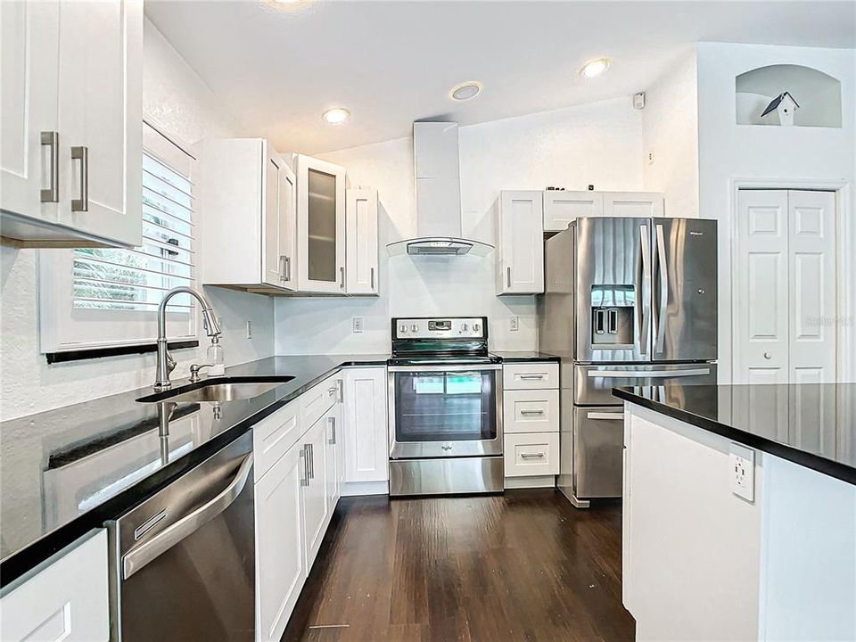 Centralized kitchen; which was recently updated in 2020, features stainless-steel appliances, granite countertops, hardwood cabinets with soft close, a breakfast bar, and a dry bar with additional cabinets for added storage.