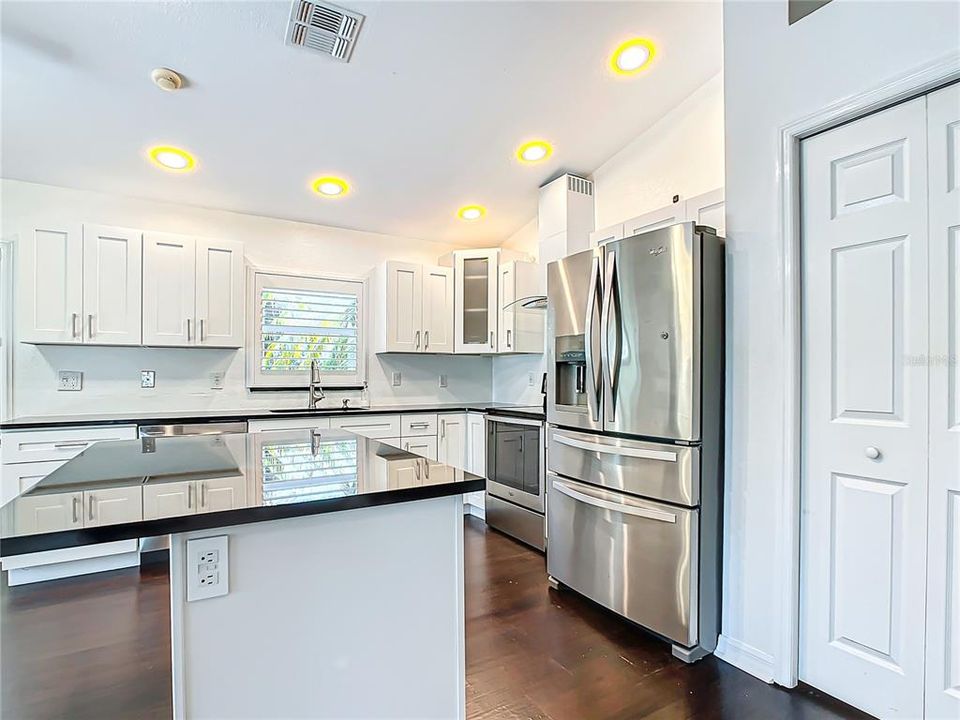 Centralized kitchen; which was recently updated in 2020, features stainless-steel appliances, granite countertops, hardwood cabinets with soft close, a breakfast bar, and a dry bar with additional cabinets for added storage.