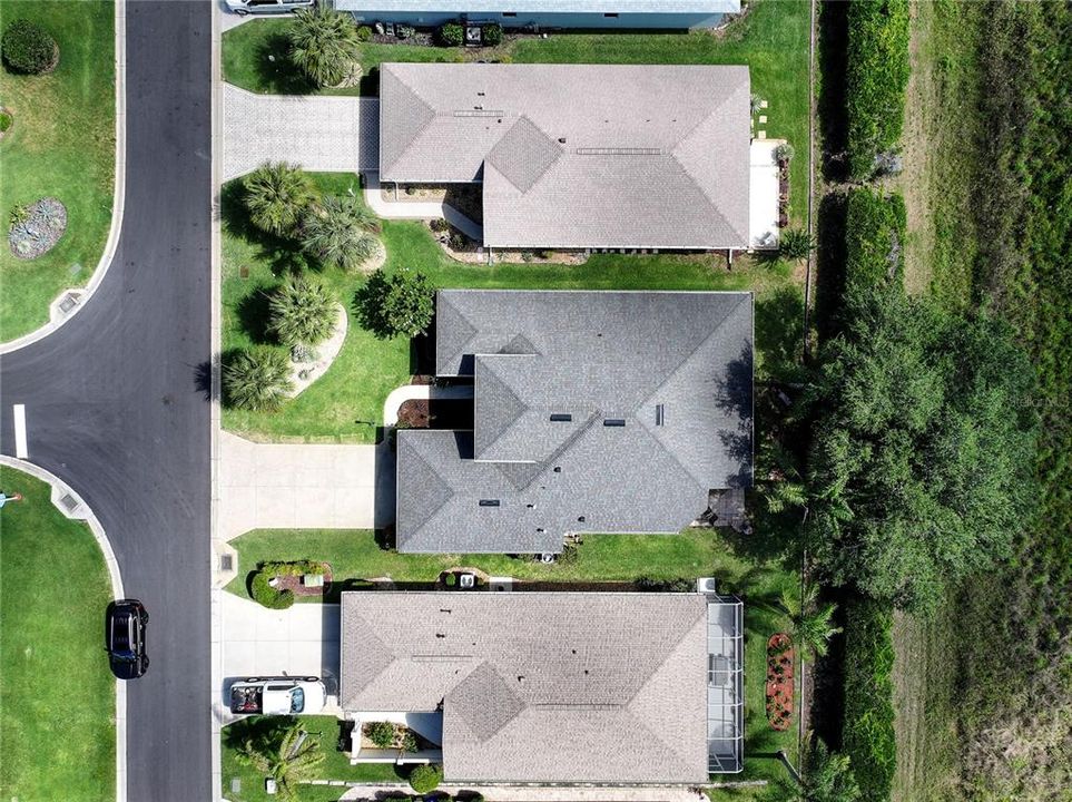 Aerial view of home. Grey roof. Mature landscaping.