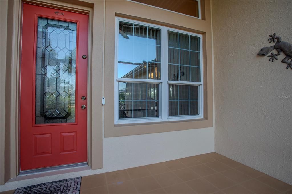 Welcoming screened front porch and lovely leaded glass entry door.