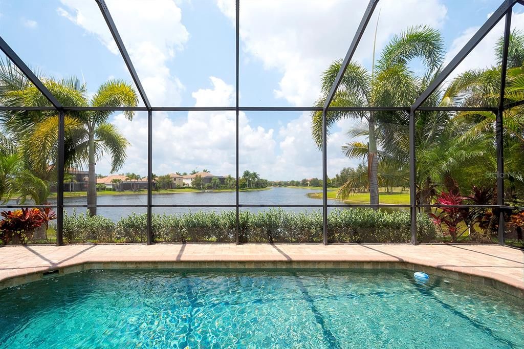 Lounge in the Pool Encompassed by Lush Landscaping and Stunning Water View