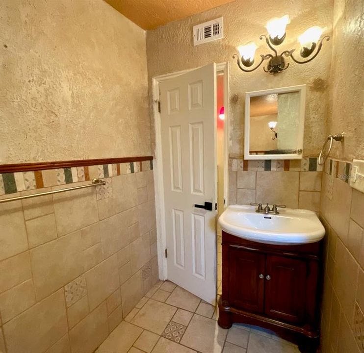 Guest bathroom vanity and door to hall.