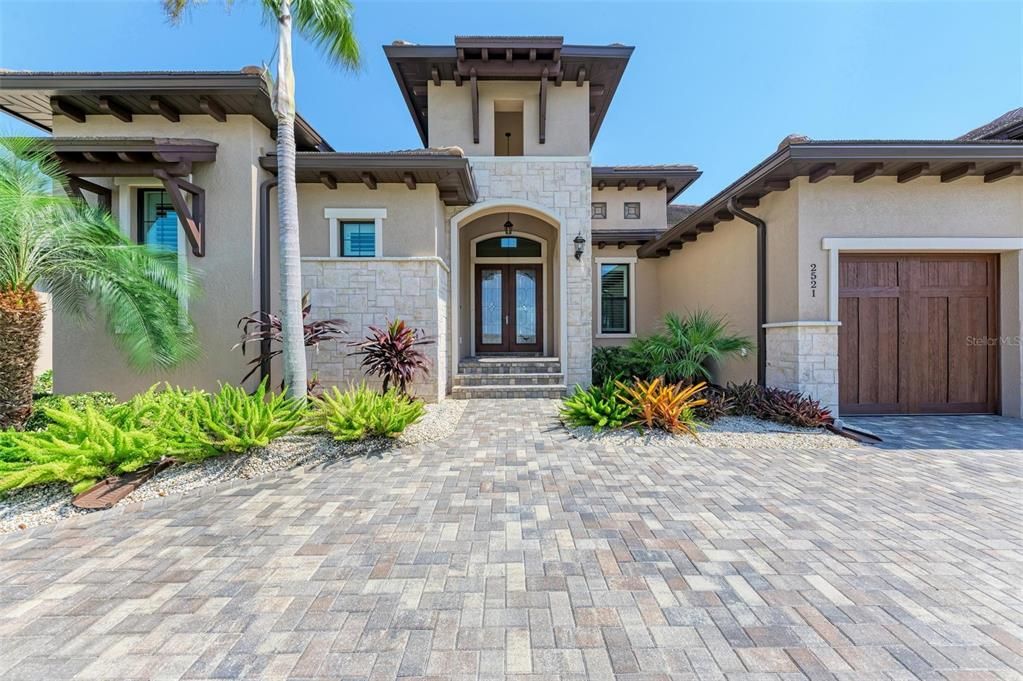 Magnificent & inviting double door entry, accented with stone cladding & warm wood tones.