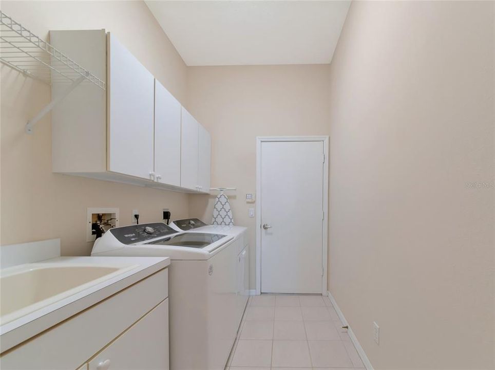 Inside laundry room, cabinets & utility sink.