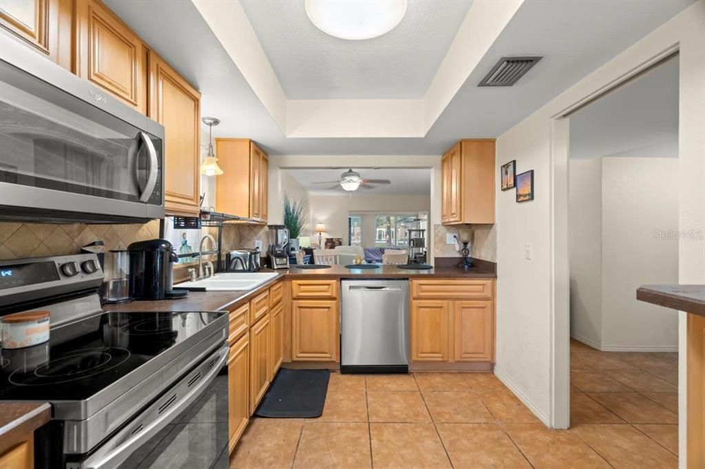 Spacious kitchen featuring ample cabinetry, stainless steel appliances, and solid surface counters.
