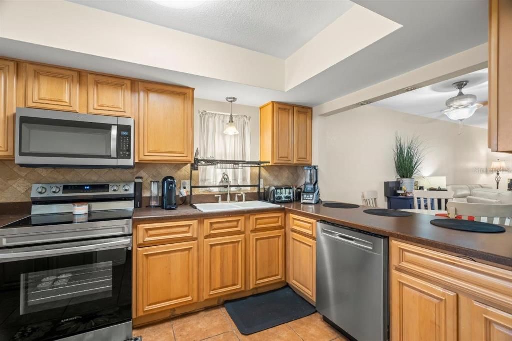 Spacious kitchen featuring ample cabinetry, stainless steel appliances, and solid surface counters.