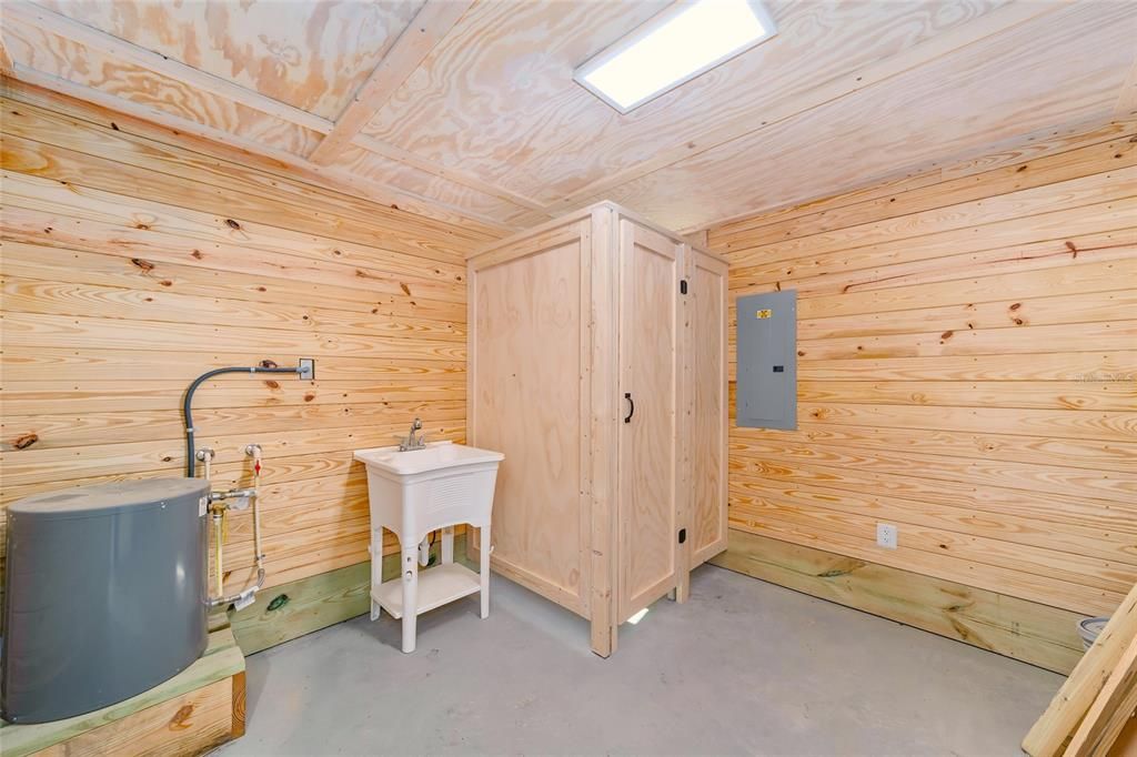 tack room with bathroom, sink and hot water heater