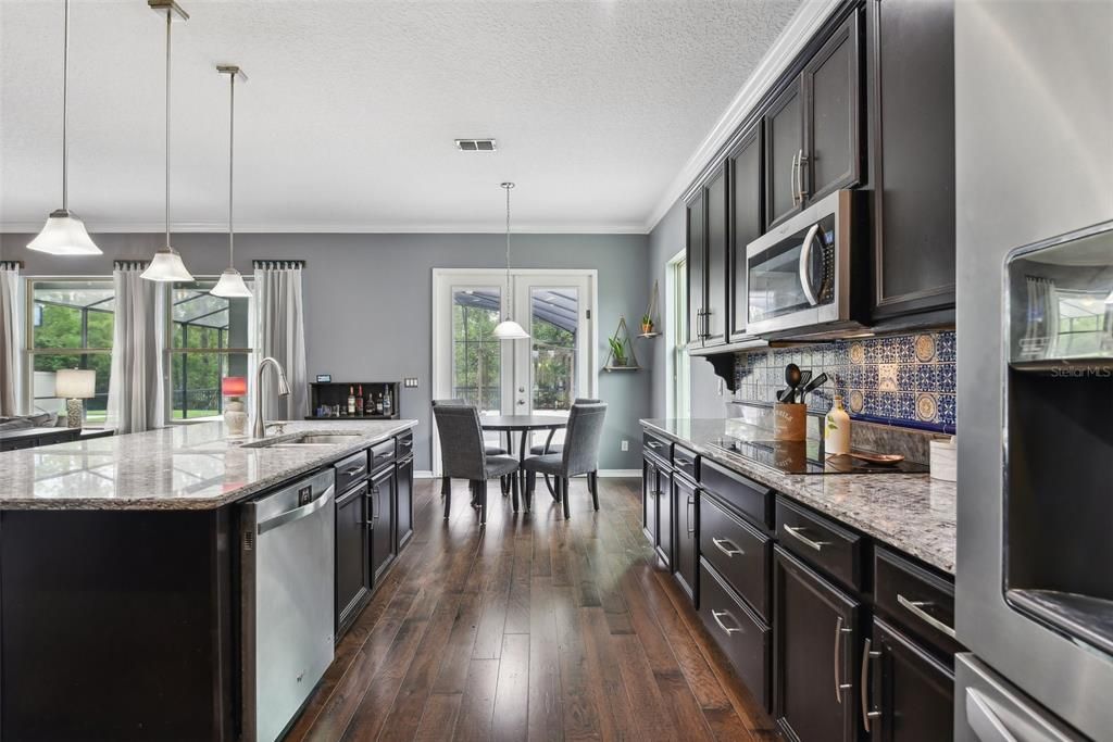 OVERSIZED CHEF’S KITCHEN with LOTS OF COUNTER AND CABINET SPACE, a WALK IN PANTRY and an OVERSIZED ISLAND overlooking the LARGE FAMILY ROOM. BEAUTIFULLY MAINTAINED WOOD FLOORS cover the majority of the DOWNSTAIRS LIVING SPACE.