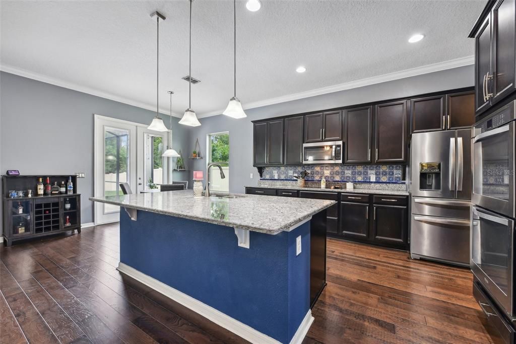 OVERSIZED CHEF’S KITCHEN with LOTS OF COUNTER AND CABINET SPACE, a WALK IN PANTRY and an OVERSIZED ISLAND overlooking the LARGE FAMILY ROOM. BEAUTIFULLY MAINTAINED WOOD FLOORS cover the majority of the DOWNSTAIRS LIVING SPACE.