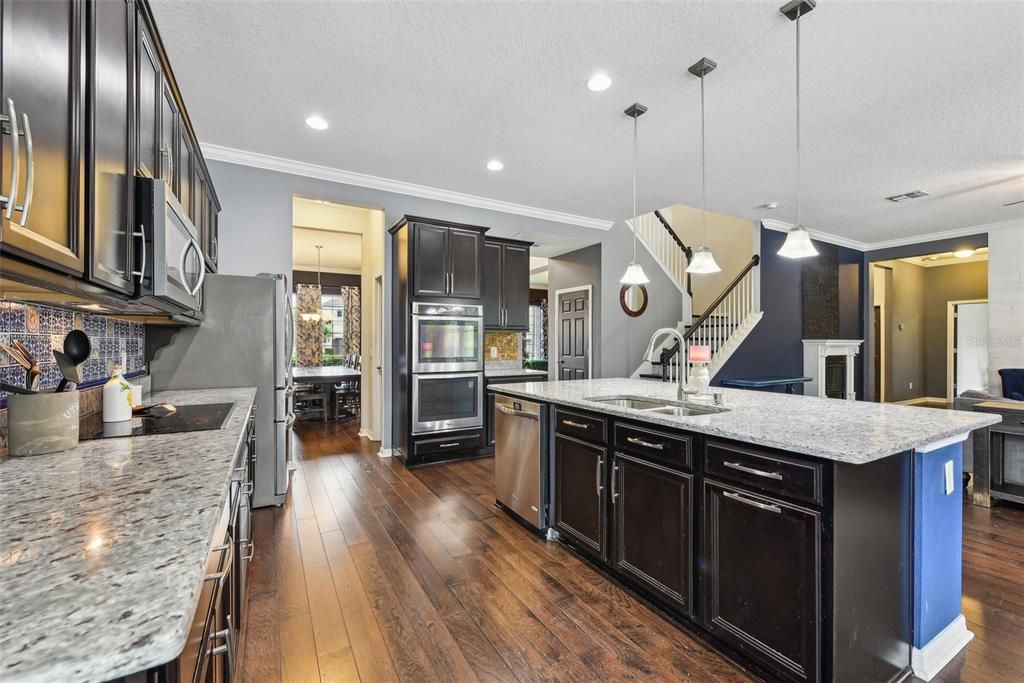 OVERSIZED CHEF’S KITCHEN with LOTS OF COUNTER AND CABINET SPACE, a WALK IN PANTRY and an OVERSIZED ISLAND overlooking the LARGE FAMILY ROOM. BEAUTIFULLY MAINTAINED WOOD FLOORS cover the majority of the DOWNSTAIRS LIVING SPACE.