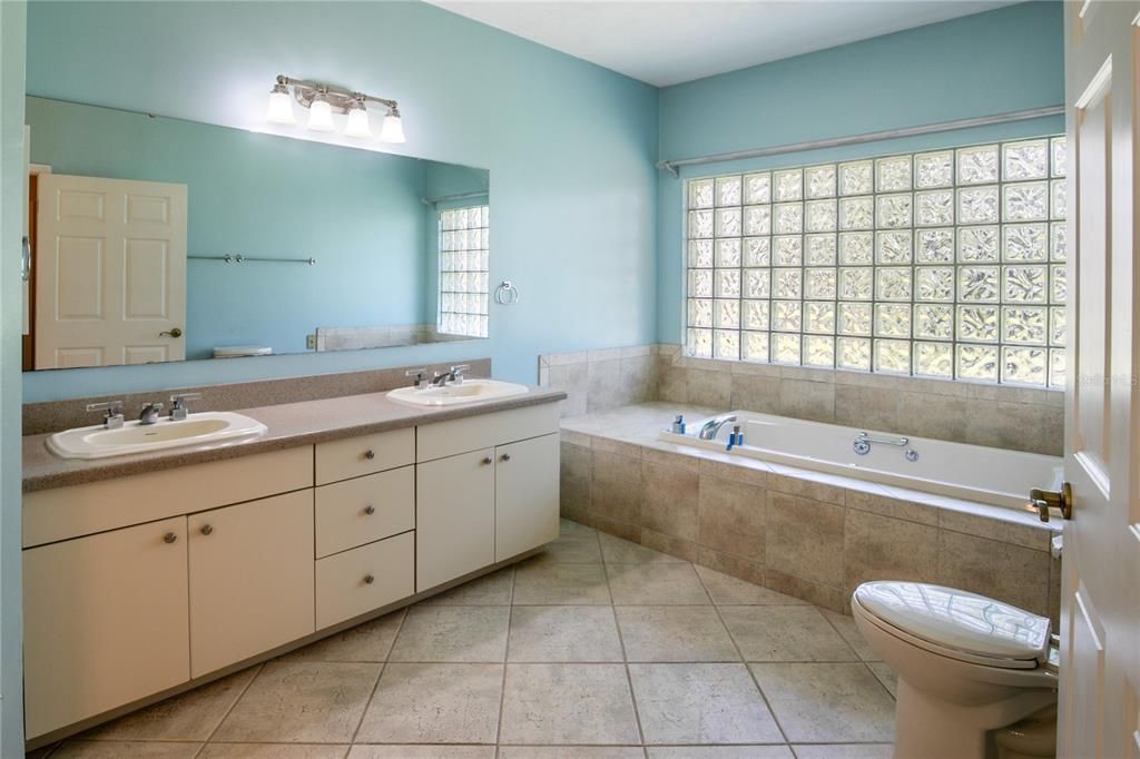 Primary Bath with double vanity, jetted tub, and shower stall.