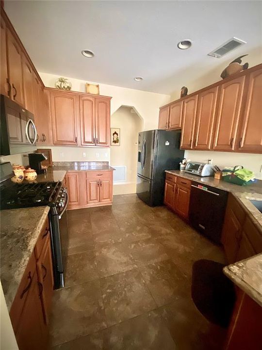 Kitchen with granite counters, wood cabinets and gas stove