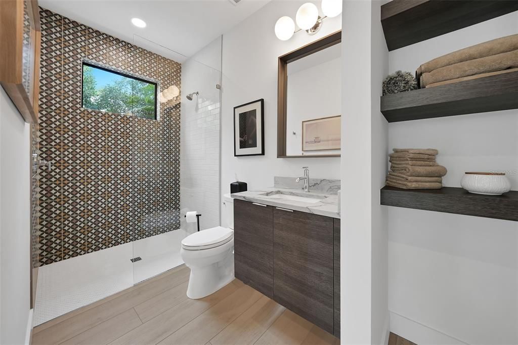 Guest Bath is ensuite to the second bedroom with Stylish Tile and Open Shelving