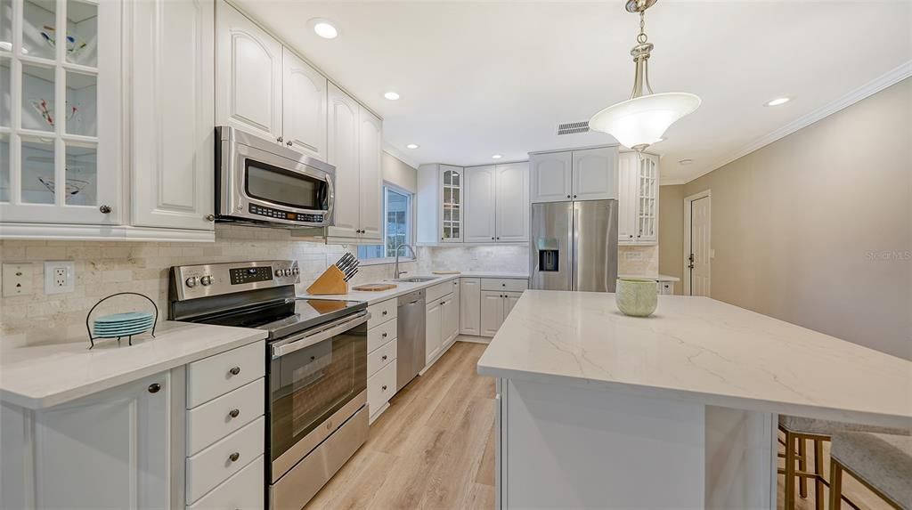 Stunning kitchen offers newer GE appliances, Bosch dishwasher, quartz countertops and under counter lighting.