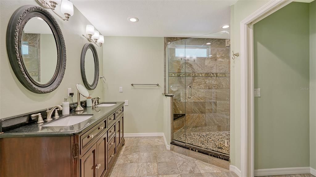 Primary ensuite bath offers dual sinks, granite countertops, large walk-in shower w/dual shower heads and private water closet.