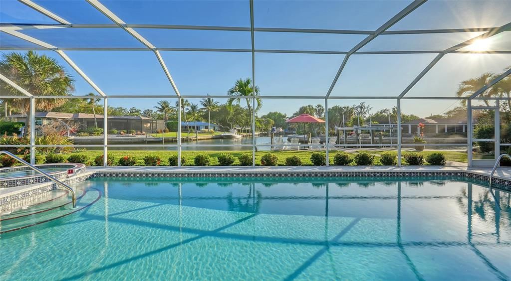 Large saltwater pool and spa with canal views beyond.