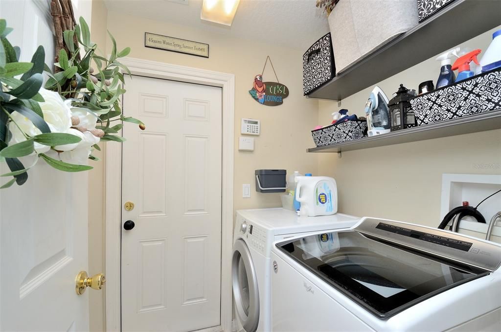 Laundry room between kitchen and garage entrance.