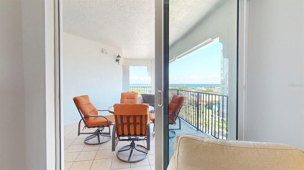 Beautiful large covered patio over 200 sq/ft with water views, accessible from 3 different sliding doors !!View from inside the primary bedroom to the balcony!