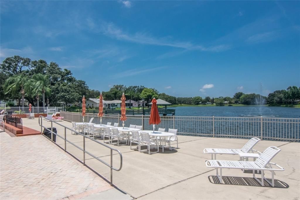 Community deck overlooking lake with fountain and fishing area