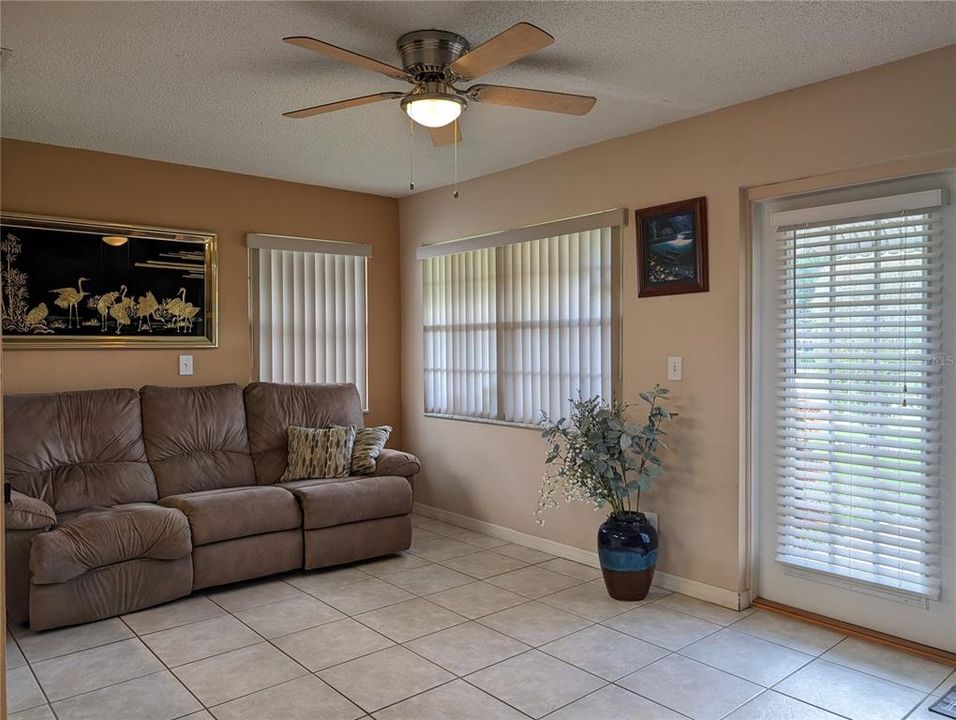 Florida room offers neutral decor, tiled flooring, ceiling fan w/light, lots of natural light and French doors to back patio.