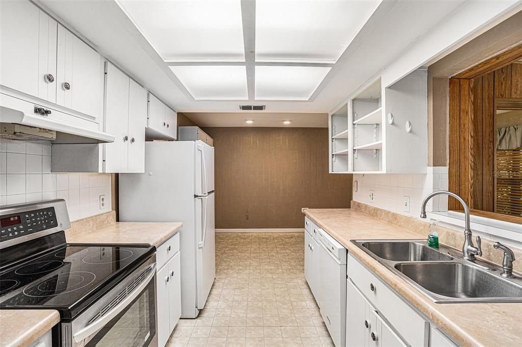 White cabinetry (doors to be reinstalled) - Bright kitchen with ample counter space