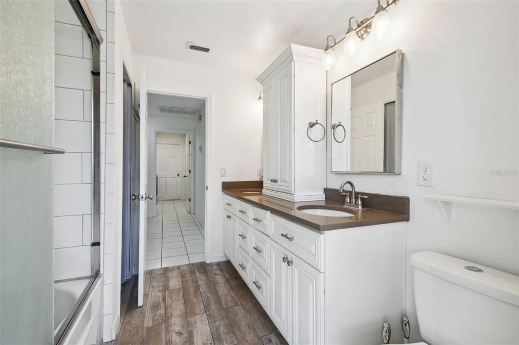 Updated bathroom 2 with dual sinks, shower/tub combo with access to pool lanai.