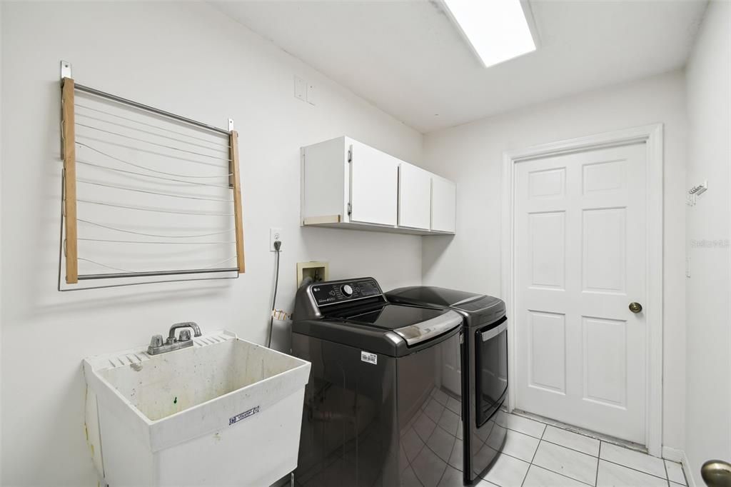 Laundry room with sink and cabinets for added storage.