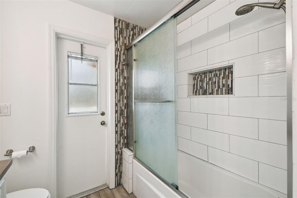 Updated bathroom 2 with dual sinks, shower/tub combo with access to pool lanai.