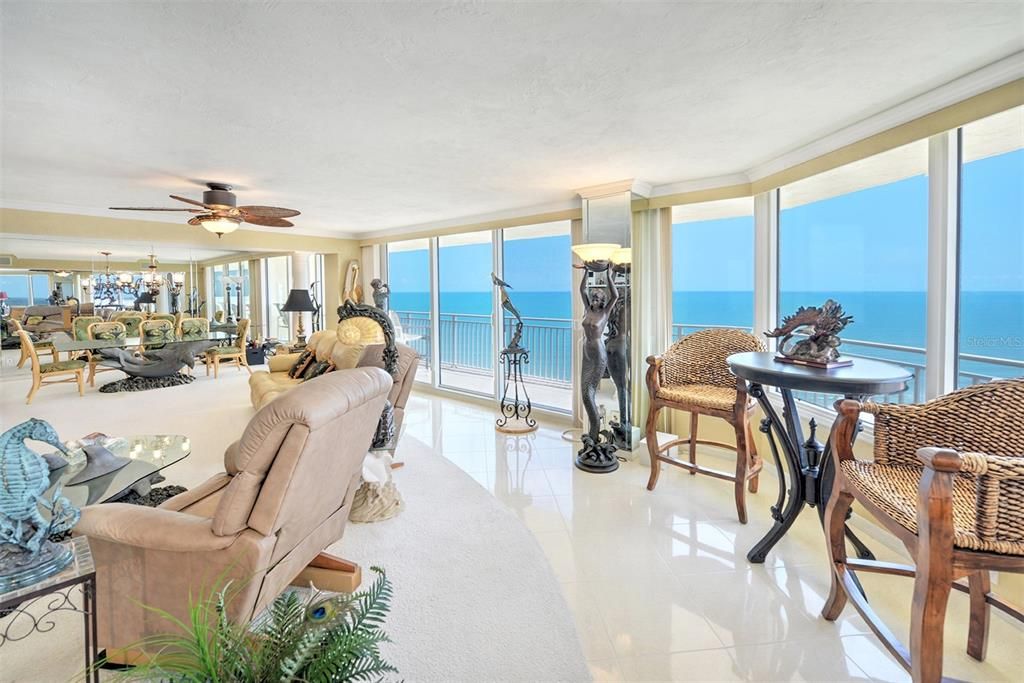 This living room, ,designed for the discerning, offers panoramic views of the ocean that stretch as far as the eye can see.
