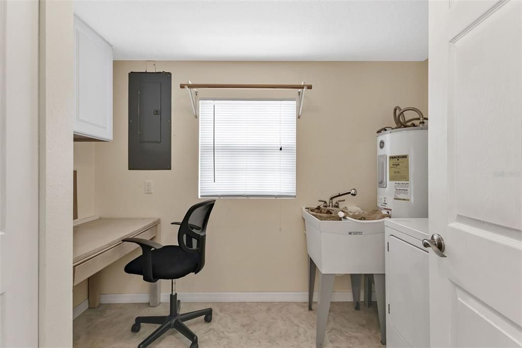 Laundry room has desk and storage closet.