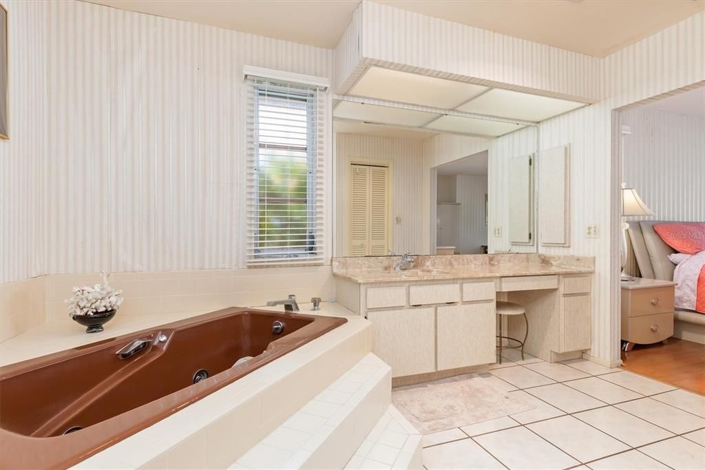 Relax in the jetted tub. A long vanity provides ample room and storage, plus a recessed area, in addition to another vanity.