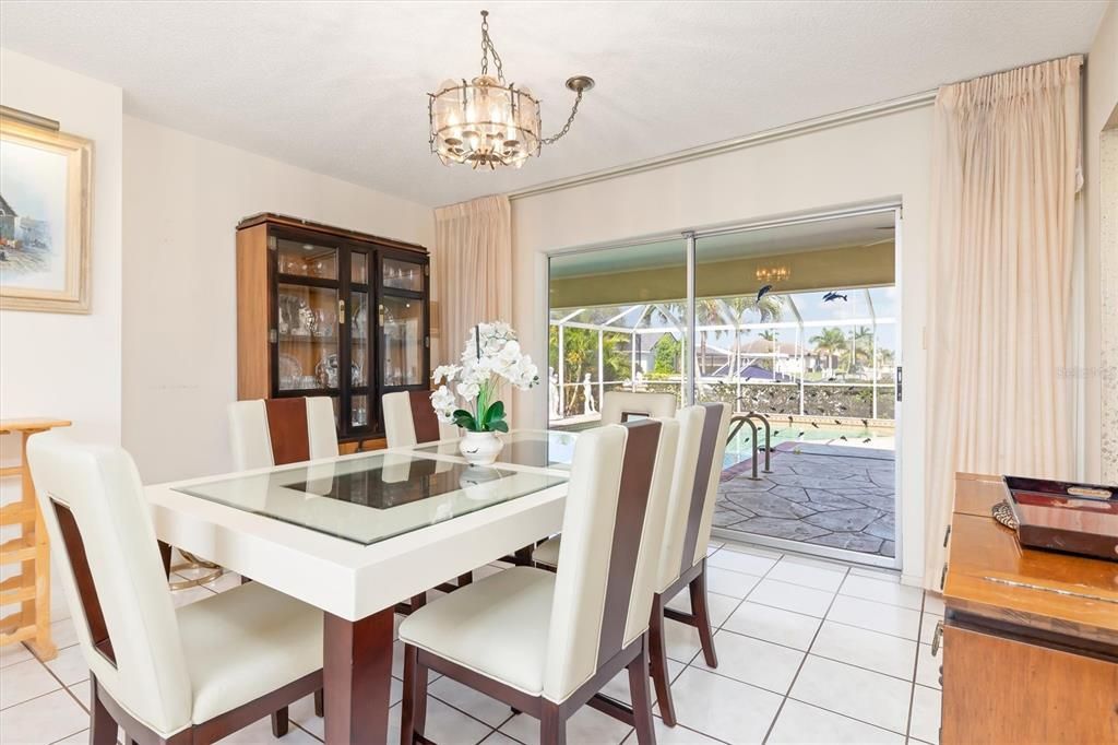 The dining area is conveniently located between the living room and dining room, and also provides easy access through the pocketed sliders to the screen lanai and pool.