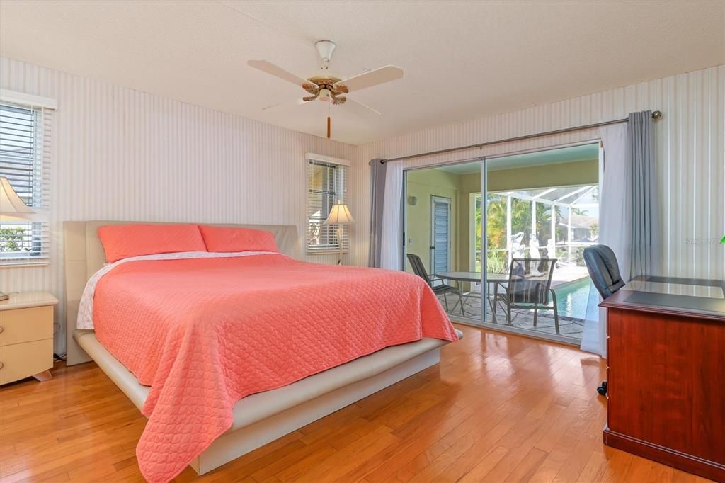 Primary bedroom with ensuite bath and sliders accessing the lanai, pool, and sauna.