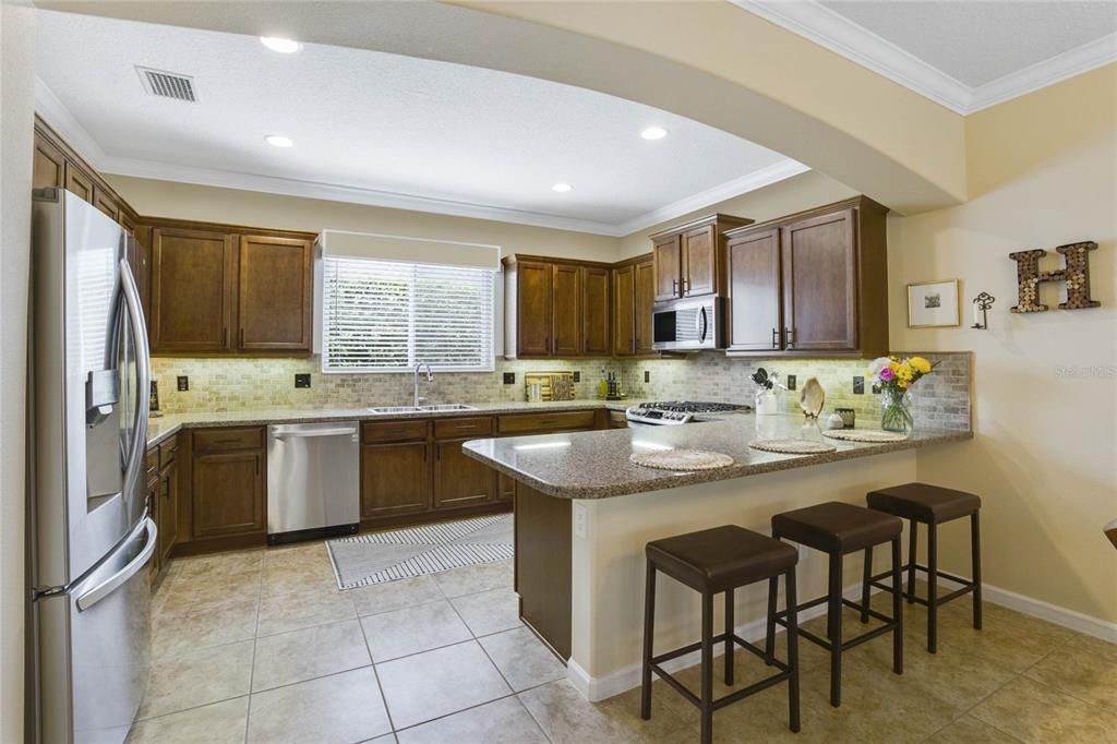 11' x 14'9" Kitchen w/ Maple cabinets, Quartz countertop, stone backsplash & stainless steel appliances