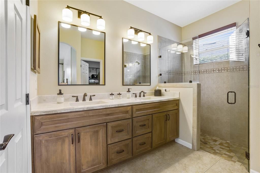 10'6" x 8' Primary Bathroom w/ stone countertop & frameless glass enclosed walk-in shower