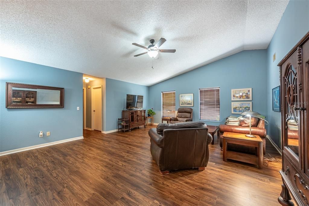 The large family room, boasts cathedral ceilings and beautiful luxury vinyl flooring.