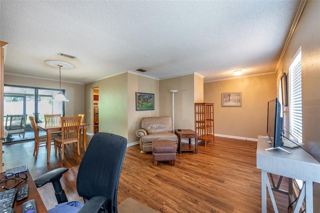 Walk into the living room/dining room combination with newly installed luxury vinyl flooring installed throughout with lots of natural light and a sliding glass door leading to a large back porch.